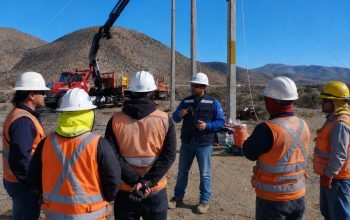 Trabajadores con cascos blancos reunidos en terreno semiarido